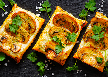 Mini mushroom tarts with puff pastry . Delicious vegetarian appetizer