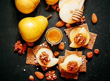 Appetizer canape with pear, honey, hazelnuts, almonds and cottag Appetizer canape with pear, honey, hazelnuts, almonds and cottag