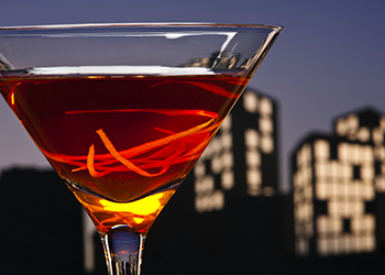 Metropolis Manhattan cocktail in city skyline setting Metropolis Manhattan cocktail in city skyline setting
