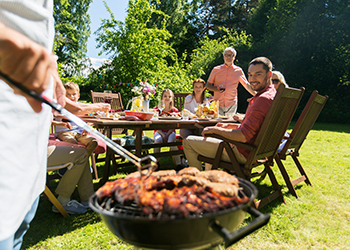 man cooking meat on barbecue grill at summer party man cooking meat on barbecue grill at summer party