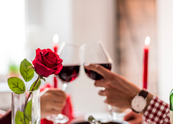 Young happy couple celebrating Valentine's day with a dinner at home drinking wine, cheers. Young happy couple celebrating Valentine's day with a dinner at home drinking wine, cheers.