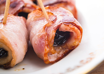 Baked prunes in bacon on a plate Baked prunes in bacon on a plate