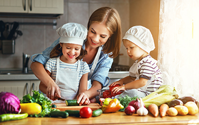 Healthy eating. Happy family mother and children prepares  vegetable salad 