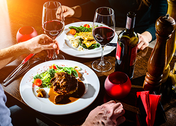 Couple having romantic dinner in a restaurant in rays of the sun Couple having romantic dinner in a restaurant in rays of the sun