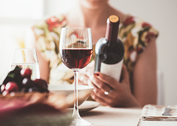 Woman reading a wine label Woman reading a wine label